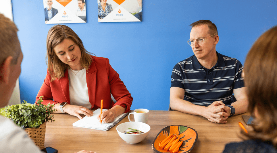 Vier personen aan een tafel in gesprek
